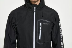 Close-up view of a stylish black sports jacket with branding on a white background.