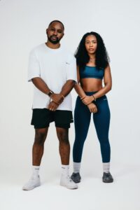 Stylish studio portrait of an athletic man and woman in fashionable sportswear with a neutral background.